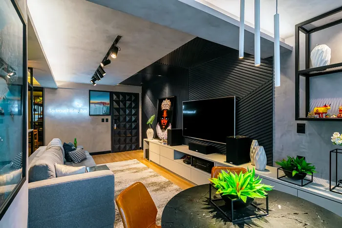 Sala de estar com painel ripado preto atrás da TV, rack suspenso claro e nichos metálicos.